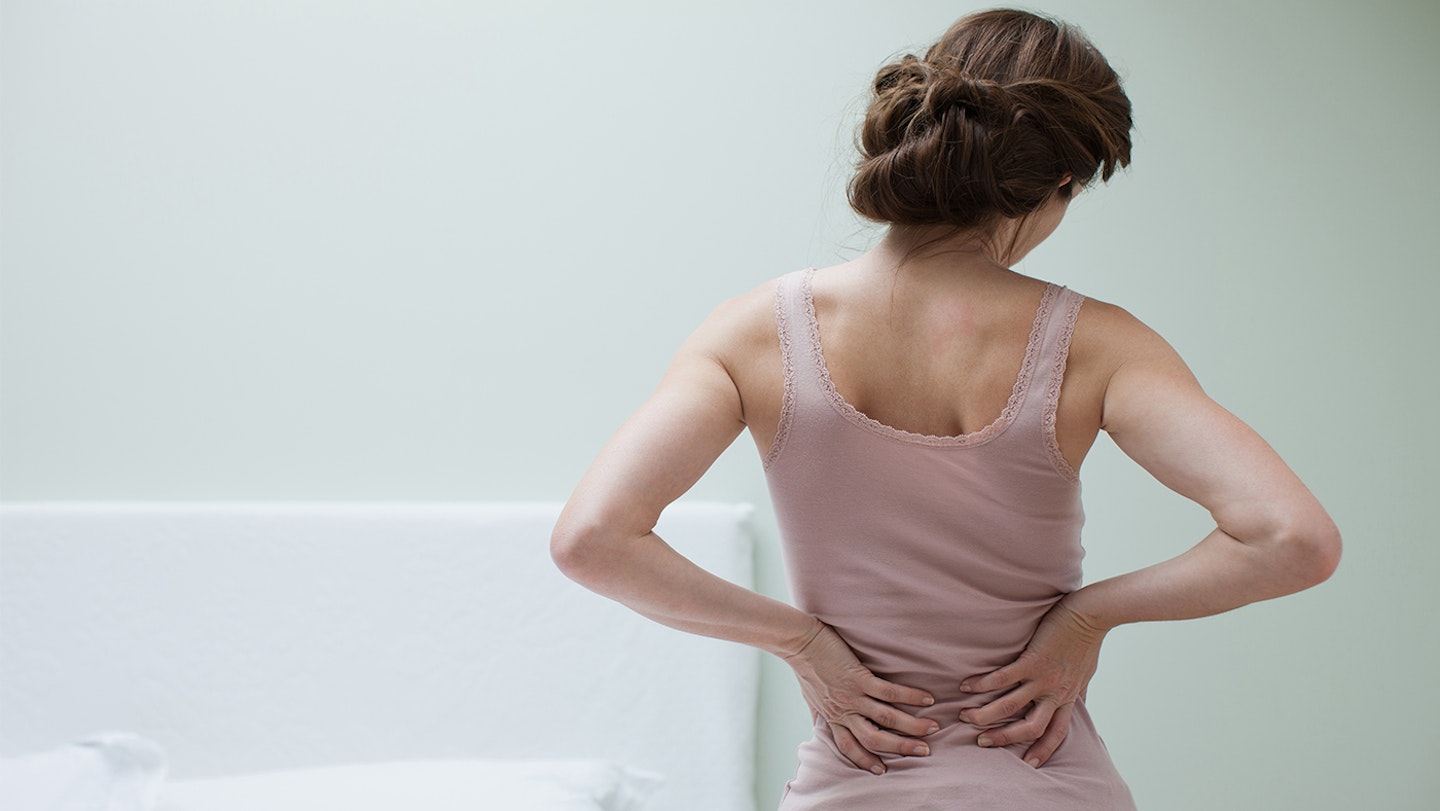 woman holding her back