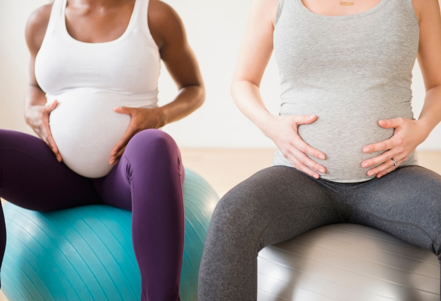 Two pregnant women sitting on balance balls in an exercise class
